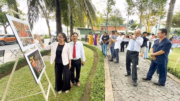 Đại biểu và khách tham quan chăm chú theo dõi các tác phẩm trưng bày.