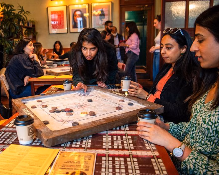 Sự kiện chơi carrom tại Dishoom Permit Room ghi nhận sức hút khổng lồ với hàng trăm người đăng ký cho một số lượng vé hạn chế. Ảnh: The Guardian