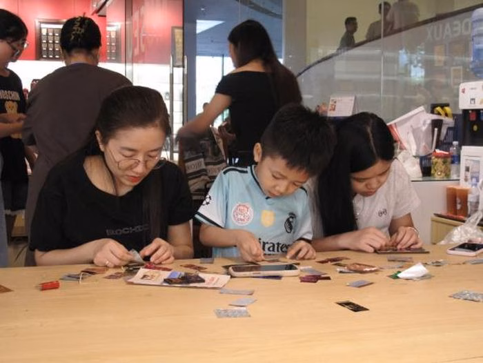 Quá trình tỉ mỉ dán lá kim loại lên phôi tranh